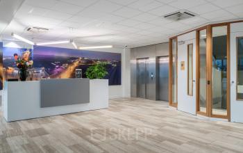 Modern office entrance with a reception desk and elevators at A. Hofmanweg 5A, Haarlem Waarderpolder. Ideal office space rental for businesses.