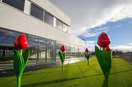 Exterior view of A. Hofmanweg 5A in Haarlem Waarderpolder, showing spacious outdoor area with decorative tulip sculptures. Ideal for businesses seeking office space rental.