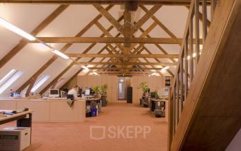 Spacious attic workspace with exposed wooden beams, furnished with desks and computers at Hendrik Figeeweg 1E, Haarlem Waarderpolder, Haarlem available for office space rental.