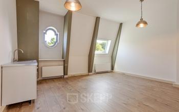 Interior view of a minimal office space for rent at Dreef 34, Haarlem Zuid, Haarlem, featuring wooden flooring, a small sink area, and modern lighting.