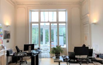 Bright office space for rental with large windows, two desks, and potted plants at Dreef 36, Haarlem Zuid, Haarlem.