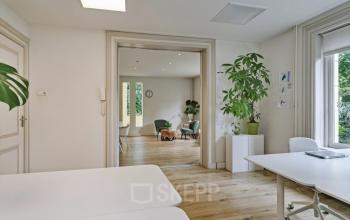 Office interior at Florapark 7, Haarlem Zuid, Haarlem showcasing a spacious, well-lit area with modern furnishings, light wood flooring, and large windows.