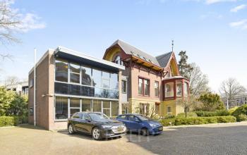 Exterior of office building located at Florapark 7, Haarlem Zuid, Haarlem featuring modern glass facade and historical architecture with parking space.