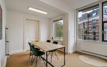 Bright office space to rent at Florapark 7, Haarlem Zuid, Haarlem, featuring large windows, a wooden table, and modern chairs.