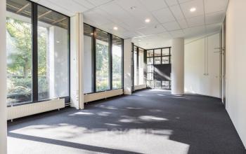 Bright, unfurnished office space rental located at Fonteinlaan 5, Haarlem Zuid, Haarlem, with large windows offering a view of the greenery outside.