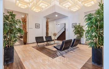 Modern reception area with stylish seating, wooden flooring, and indoor plants at office space rental located at Fonteinlaan 5, Haarlem Zuid, Haarlem.