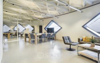 Modern office space rental at Suikersilo Oost-West 1-41 in Halfweg with triangular windows, contemporary furniture, and polished floors.