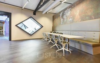Modern office space rental at Suikersilo Oost-West 1-41, Halfweg, featuring a long desk with stylish chairs and contemporary decor.