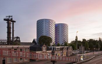 Modern office space rental at twilight in Suikersilo Oost-West 1-41, Halfweg with iconic cylindrical buildings.
