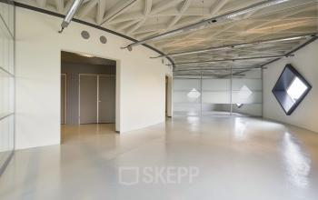 Modern office space rental at Suikersilo Oost-West 1-41 in Halfweg featuring geometric lighting and polished floors.