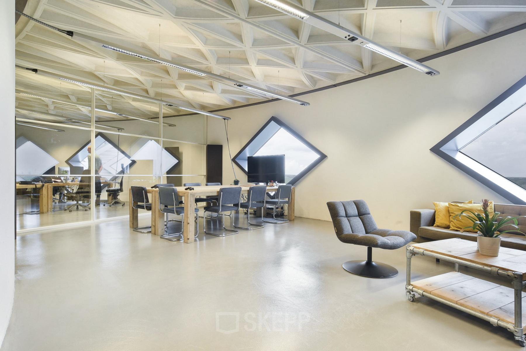 Modern office space rental at Suikersilo Oost-West 1-41 in Halfweg with triangular windows, contemporary furniture, and polished floors.
