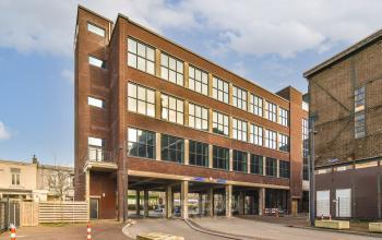 Exterior view of an office building at Haarlemmerstraatweg 13 in Halfweg, perfect for office space rental, featuring large windows and modern brick design.