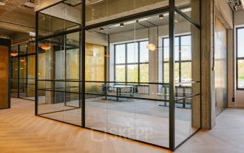 Modern office space in Halfweg featuring glass partitions, natural light, and contemporary design, ideal for office space rental.