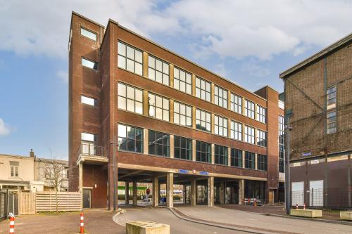 Exterior view of an office building at Haarlemmerstraatweg 13 in Halfweg, perfect for office space rental, featuring large windows and modern brick design.