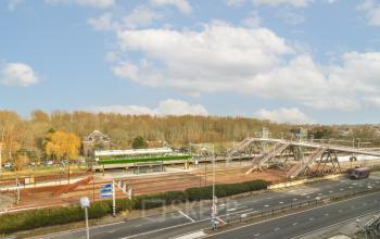 Exterior view of Haarlemmerstraatweg 13A office building in Halfweg, including train tracks, roads, and surrounding area.