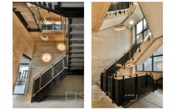 Interior view of modern concrete staircase with black railings and circular lights at Haarlemmerstraatweg 13A, Halfweg.