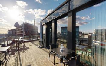 Moderne Büroterrasse an der Domstraße 10 in Hamburg Altstadt mit Sitzmöglichkeiten und Sonnenlicht.