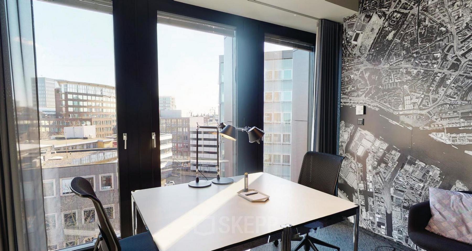 Modern office space at Domstraße 10 in Hamburg Old Town with large windows and city views, featuring a desk, chairs, and a wall map.