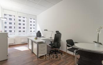 Bright office space for rent at Raboisen 38, Hamburg Old Town, featuring large windows, desks, and chairs, ideal for work activities.