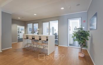Interior office at Raboisen 38 in Hamburg Old Town with a high table and chairs. Ideal office space rental, featuring a modern and minimal design.