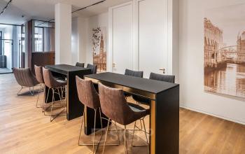 Moderner Büroraum mit hohen Tischen und eleganten Stühlen im Ballindamm 27, Hamburg Altstadt, ideal für Büroraum mieten.