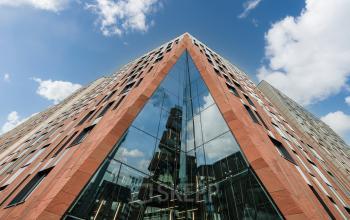 Exterior view of the modern office building at Überseeallee 1, Hamburg Hafencity, with distinctive angular architecture and reflective glass facade. Ideal for office space rental with its unique design and prime location.