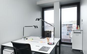 Helles Büro mit modernen Möbeln und großen Fenstern
