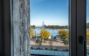 Ausblick aus einem Bürofenster auf den Hamburger Jungfernstieg, mit Blick auf die Binnenalster und den strahlend blauen Himmel. Eine Möglichkeit, im beliebten Stadtteil Hamburg-Neustadt einen Büroraum zu mieten.