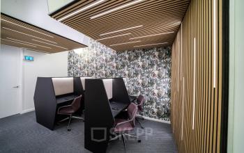 Moderner Büroraum mit Arbeitsplätzen zur Miete in Hamburg Neustadt, Neuer Wall 10. Der Raum ist mit stilvollen Trennwänden und bequemen Stühlen ausgestattet, ideal für konzentriertes Arbeiten.