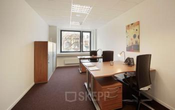 Möbliertes Büro in Hannover Mitte mit zwei Arbeitsplätzen, Schränken und Fensterblick zur Bahnhofstraße. Ideal für eine Bürofläche mieten oder Büroraum mieten.