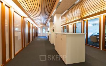 Bright office corridor at Herenweg 115, Heemstede, featuring wooden accents and modern furnishing, ideal for office space rental.