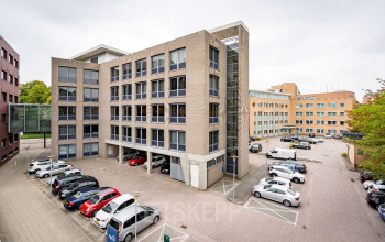 View of the office building at Geerstraat 115, Heerlen, with ample parking space, ideal for office space rental.