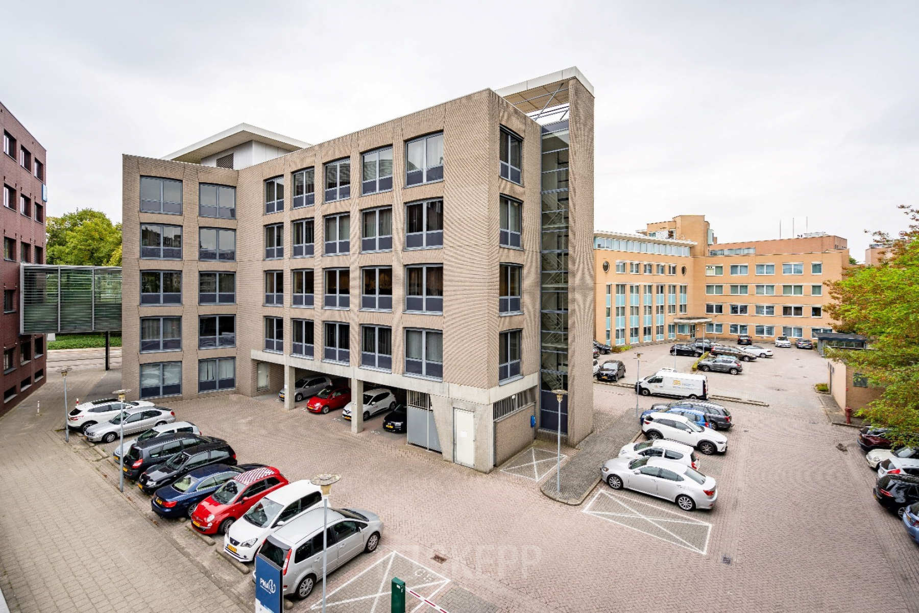 View of the office building at Geerstraat 115, Heerlen, with ample parking space, ideal for office space rental.