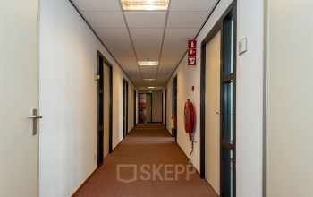 Hallway of office space at Milaanstraat 70-110, Heerlen, featuring closed doors and a fire extinguisher, ideal for office space rental.