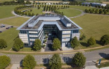Exterior view of the modern office building located at Snellius 1, Heerlen, suitable for office space rental, surrounded by greenery and scenic landscaping.