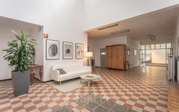 Spacious office lobby at Oliemolenstraat 60, Heerlen, featuring comfortable seating, potted plants, and decorative art pieces, ideal for office space rental.