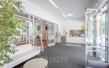 Bright office entrance at Oliemolenstraat 60, Heerlen featuring seating area and glass-walled conference rooms, available for office space rental.