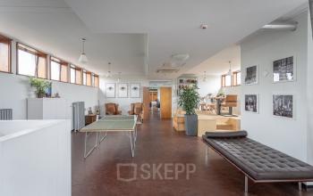 Spacious office area at Oliemolenstraat 60, Heerlen with mixed seating including desks, armchairs, and plants, ideal for workspaces. Office space rental available.