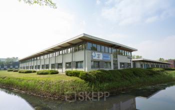 Exterior view of office building located at Steenovenweg 5, Helmond, Helmond with well-maintained grounds and water feature in the foreground.