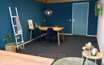 Inviting office space at Steenovenweg 5, Helmond, with a wooden table, chairs, and greenery, ideal for office space rental.
