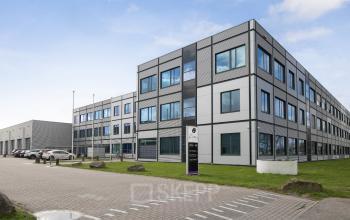 Exterior view of an office building located at Jan Tinbergenstraat 202, Hengelo, showcasing a modern facade. Ideal for office space rental, the site includes ample parking and easy access.