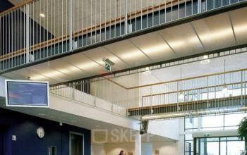 Spacious office interior at Jan Tinbergenstraat 202 in Hengelo, featuring a modern reception area with seating and a balcony view. Ideal for office space rental.