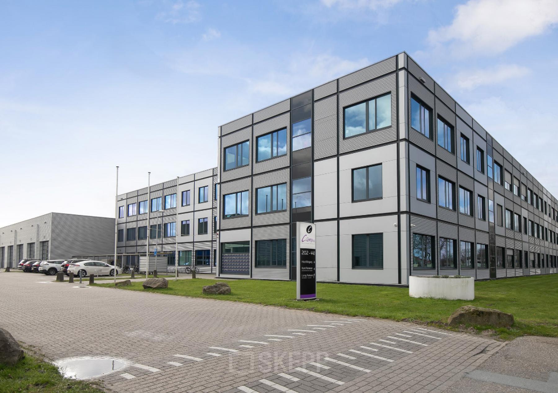 Exterior view of an office building located at Jan Tinbergenstraat 202, Hengelo, showcasing a modern facade. Ideal for office space rental, the site includes ample parking and easy access.