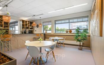 Bright office to rent at Hazenweg 2-2 Hengelo, featuring spacious tables, ample natural light, and a cozy atmosphere ideal for collaborative work.