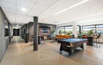 Comfortable lounge area with a pool table in an office space at Hazenweg 2 2, Hengelo, available for office space rental.