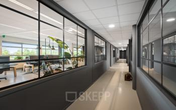 Modern office space rental in Hazenweg 2 2, Hengelo featuring a spacious hallway with large windows offering views of bright, airy workspaces.