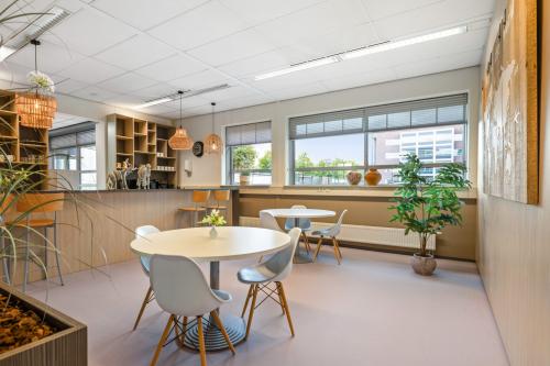 Bright office to rent at Hazenweg 2-2 Hengelo, featuring spacious tables, ample natural light, and a cozy atmosphere ideal for collaborative work.