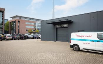 Exterior view of the office building at Lintelerweg 40, Hengelo, with parking area and several cars.