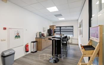 Modern kitchenette area in the office space rental at Lintelerweg 40, Hengelo, Hengelo, with seating, coffee machine, and storage cabinets.