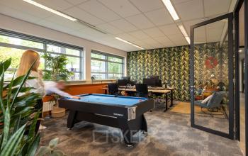 Office space rental at Demmersweg 41-47, Hengelo with desk workstations, chairs, and a pool table in a vibrant and modern setting.